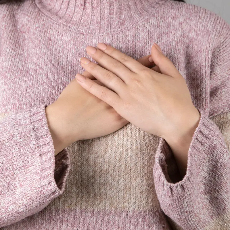 female with her hands over her heart