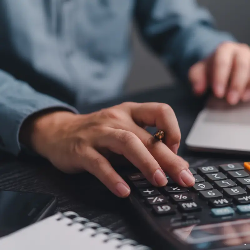 Person at a desk using a calucator