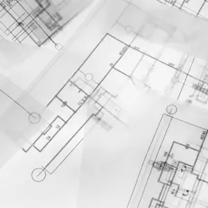 close up transperent erasable building plans laid out on a table